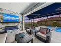 Covered patio with outdoor fireplace, seating area, and pool view at 6741 Rookery Lake Dr, Bradenton, FL 34212