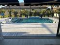 Relaxing screened pool with a sun shelf and tiled water feature offers a private outdoor oasis at 6741 Rookery Lake Dr, Bradenton, FL 34212
