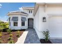 Home entrance displaying the covered entryway and manicured landscaping at 7661 Moonbeam Ave, Sarasota, FL 34241