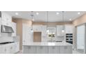 Modern kitchen featuring a spacious island, stainless steel appliances, and white cabinetry at 7661 Moonbeam Ave, Sarasota, FL 34241