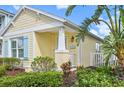 Charming yellow cottage with light blue shutters and welcoming porch at 12622 Shimmering Oak Cir, Venice, FL 34293