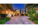 Elegant home exterior featuring a paver driveway, lush landscaping, and a welcoming entrance with decorative accents at 7928 Matera Ct, Lakewood Ranch, FL 34202