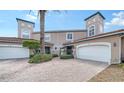 Exterior view of two-story townhome with attached garage and brick driveway at 1713 Starling Dr # 1713, Sarasota, FL 34231