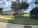 Tan two-car garage villa with lush landscaping and paved driveway at 8191 Varenna Dr, Sarasota, FL 34231