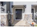 Front entry with stone accents and black door at 8685 Daydream St, Sarasota, FL 34238