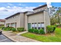 Tan two-story condo with green door, landscaping, and walkway at 4418 Rayfield Dr # D-3132, Sarasota, FL 34243