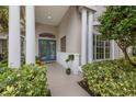 Inviting front entry with teal double doors and lush landscaping at 8223 Regents Ct, University Park, FL 34201