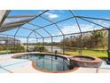 Screened-in pool and spa overlook a tranquil lake view in this home's private backyard oasis at 115 Winding River Trl, Bradenton, FL 34212