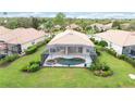 Aerial view of a screened-in pool and hot tub surrounded by lush landscaping and well-maintained lawns at 115 Winding River Trl, Bradenton, FL 34212