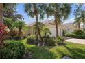 Single story home with palm trees and landscaped yard at 5793 Ithaca Way, Sarasota, FL 34238