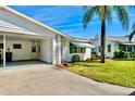 Charming home featuring a carport, well-kept lawn, and a beautiful palm tree under a blue sky at 6006 Hibiscus Dr # 6006, Bradenton, FL 34207