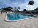 Beautiful community pool with chairs, set amidst palm trees and well-maintained surroundings on a cloudy day at 6006 Hibiscus Dr # 6006, Bradenton, FL 34207