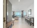 Bright entryway with concrete wall and wood bench, leading to spacious living area with water views at 800 N Tamiami Trl # 1603, Sarasota, FL 34236