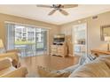 Living room with comfy seating, flat-screen TV, and sliding glass doors leading to a patio at 9320 Clubside Cir # 2109, Sarasota, FL 34238