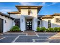 Modern home entrance with a paver walkway and lush landscaping at 1209 Blue Shell Loop, Sarasota, FL 34240