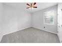 Neutral bedroom featuring plush carpet, ceiling fan, and a bright window at 3718 Mossy Limb Ct, Palmetto, FL 34221