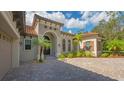 Attractive home exterior with tile roof, arched entryway and landscaped grounds at 9291 Swaying Branch Rd, Sarasota, FL 34241