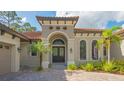 House entrance with arched entry, decorative door and lush landscaping at 9291 Swaying Branch Rd, Sarasota, FL 34241