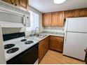Compact kitchen with white appliances, wood cabinets, and light countertops at 1570 Pleasant Rd # J-26, Bradenton, FL 34207