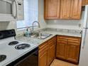 Kitchen with white appliances, wood cabinets, and light countertops at 1570 Pleasant Rd # J-26, Bradenton, FL 34207