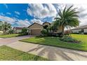 Well-kept front exterior with a brick driveway, lush lawn, and beautiful landscaping, enhancing its charm at 6547 Willowshire Way, Bradenton, FL 34212
