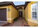 Front entrance of a yellow house with walkway at 6935 74Th Street E Cir, Bradenton, FL 34203