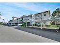 Exterior of condo building with carports, well-maintained landscaping, and ample parking at 7201 29Th Avenue W Dr # 309, Bradenton, FL 34209