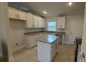 Modern kitchen featuring granite countertops, white cabinets, and a kitchen island at 890 Indus Rd, Venice, FL 34293