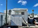 Rear view of a mobile home with a shed and satellite dish at 3710 Gulf Of Mexico Dr # F1, Longboat Key, FL 34228