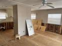 Bright living room needing renovation, features ceiling fan, original paneling, plywood subfloor, plumbing and electrical exposed at 3710 Gulf Of Mexico Dr # F1, Longboat Key, FL 34228