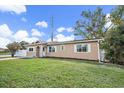 Tan house with white trim, a white fence, and a lawn at 15 Tulane Rd, Venice, FL 34293