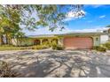 Ranch-style home with a two-car garage and mature landscaping at 2308 Palma Sola Blvd, Bradenton, FL 34209