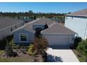 Charming home featuring a two-car garage, front yard landscaping, and a neutral color scheme at 5719 Woodland Sage Dr, Sarasota, FL 34238