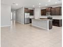 Open concept kitchen features dark cabinetry, a large island, stainless steel appliances, and tile flooring at 5719 Woodland Sage Dr, Sarasota, FL 34238