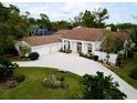 Stunning property featuring a circular driveway, manicured landscaping, and a beautiful facade with white columns at 7317 Crape Myrtle Way, Sarasota, FL 34241