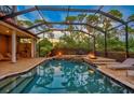 Expansive pool and patio area with fire pit and outdoor kitchen at 854 Macewen Dr, Osprey, FL 34229