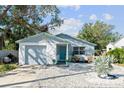 Charming light blue home with a stone facade and gravel driveway at 1105 58Th S St, Gulfport, FL 33707