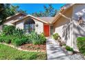 Pathway to red front door with nicely landscaped walkway at 1590 Suwanee Ct, Sarasota, FL 34232