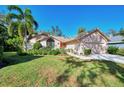 Tan house with red door, two-car garage, and grassy yard at 1590 Suwanee Ct, Sarasota, FL 34232