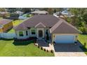 Aerial view of a single-story home featuring a well-manicured lawn, brick driveway, and attached garage at 1900 Colleen St, Sarasota, FL 34231
