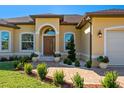Charming front entrance with a decorative doorway, manicured landscaping, and a brick pathway at 1900 Colleen St, Sarasota, FL 34231