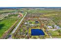 Aerial view of a house with a large lot and pond at 29205 Saddlebag Trl, Myakka City, FL 34251