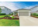 Newly built home with gray exterior, landscaping, and two-car garage at 14132 Campfire Ct, Parrish, FL 34219