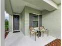 Inviting front porch with gray door and two chairs at 14132 Campfire Ct, Parrish, FL 34219