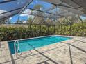 Inviting screened pool with a spacious patio and lush tropical landscaping at 1661 Atwater Dr, North Port, FL 34288