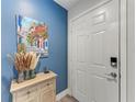 Bright entryway with white door, blue accent wall, and console table at 2412 Fairway Oaks Dr, Palmetto, FL 34221