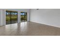 Spacious living room with tile floors, large sliding glass doors, and vaulted ceilings at 3119 Heatherwood Ln, Sarasota, FL 34235