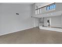 Open living area with tile floors, high ceilings, and loft area with railing at 3119 Heatherwood Ln, Sarasota, FL 34235