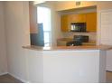 Modern kitchen with wood cabinets, black appliances, and a breakfast bar at 5701 Soldier Cir # 104, Sarasota, FL 34233