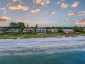 Beautiful beach front properties line the shore with fluffy clouds overhead at 5861 Gulf Of Mexico Dr, Longboat Key, FL 34228